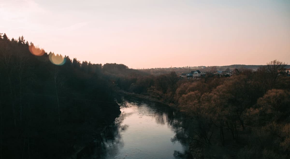 A calm river reflecting the dawn sky